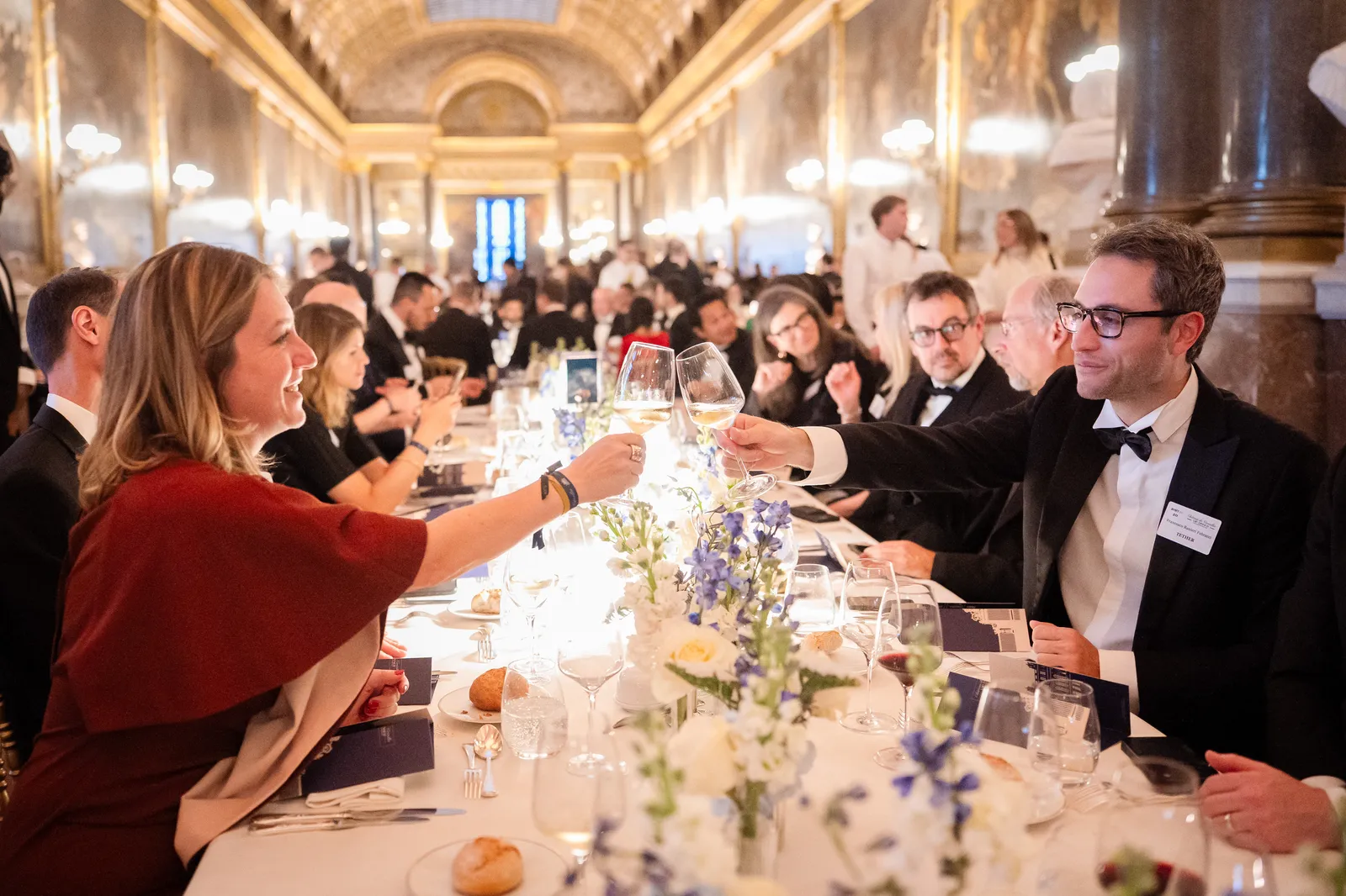 The seated VIP dinner beneath the chandeliers